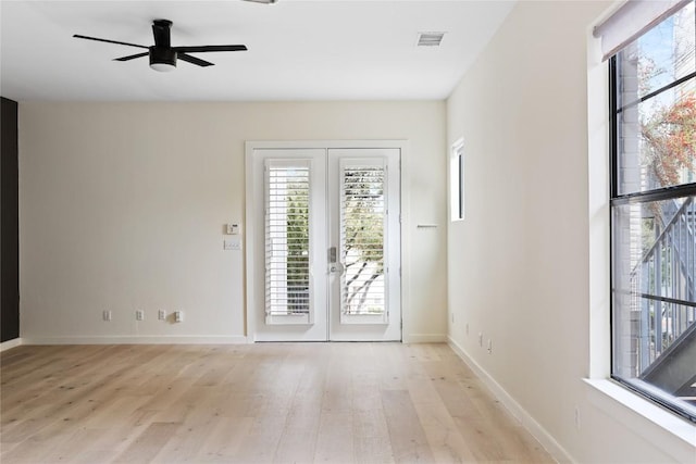 interior space with a healthy amount of sunlight, light wood-type flooring, visible vents, and french doors