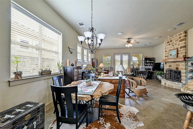 102 Maravilla Way, Horseshoe Bay, TX 78657 - tiled dining area with a chandelier, a ceiling fan, and a stone fireplace