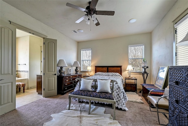102 Maravilla Way, Horseshoe Bay, TX 78657 - bedroom with light carpet, ceiling fan, and connected bathroom