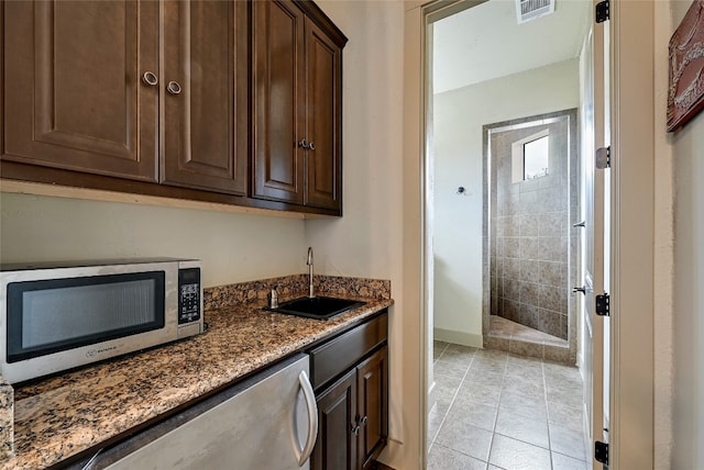 102 Maravilla Way, Horseshoe Bay, TX 78657 - kitchen featuring stainless steel microwave, dark stone counters, and dark brown cabinets
