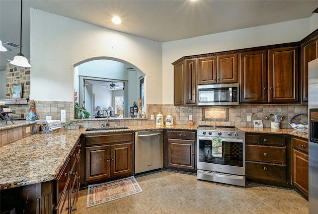 102 Maravilla Way, Horseshoe Bay, TX 78657 - kitchen featuring stainless steel appliances, dark brown cabinets, decorative backsplash, light stone counters, and ceiling fan