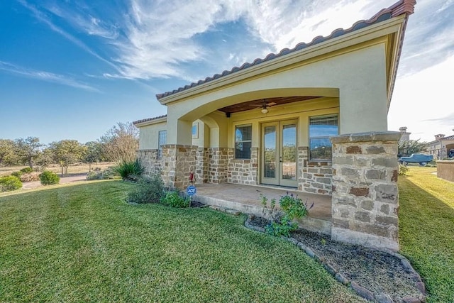 102 Maravilla Way, Horseshoe Bay, TX 78657 - rear view of house featuring a yard, french doors, a ceiling fan, stucco siding, and a tile roof