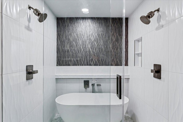 full bath featuring tiled shower, a freestanding bath, and tile walls