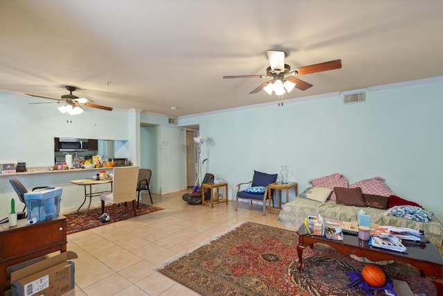 living area with light tile patterned floors, ceiling fan, visible vents, and ornamental molding