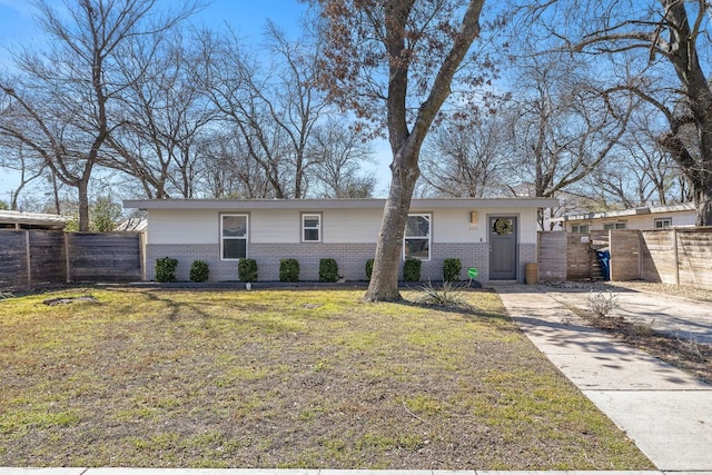 view of front of property with brick siding, a front lawn, fence, and a gate