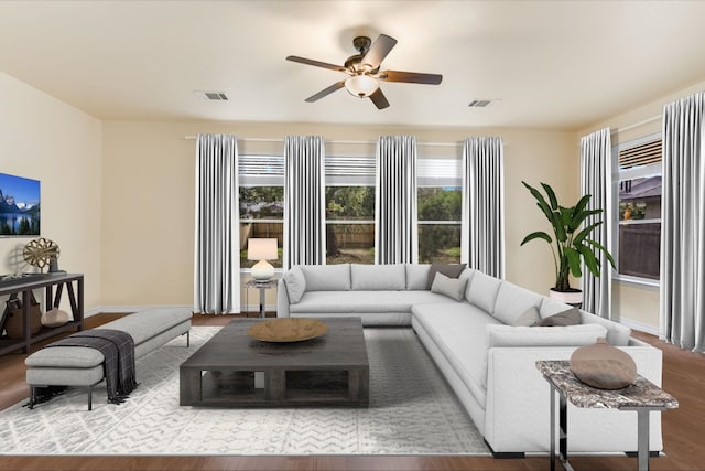 living area featuring ceiling fan, wood finished floors, and visible vents