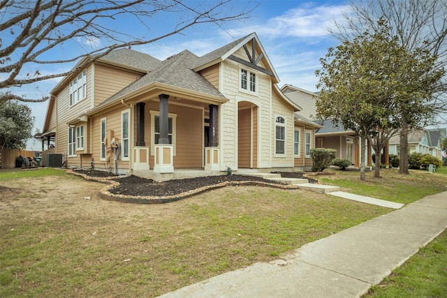 view of front of property with roof with shingles, a front lawn, and central air condition unit