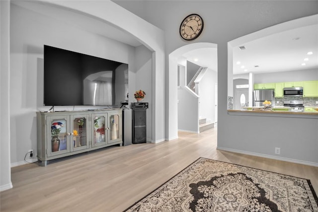 living area featuring light wood finished floors, stairway, recessed lighting, and baseboards