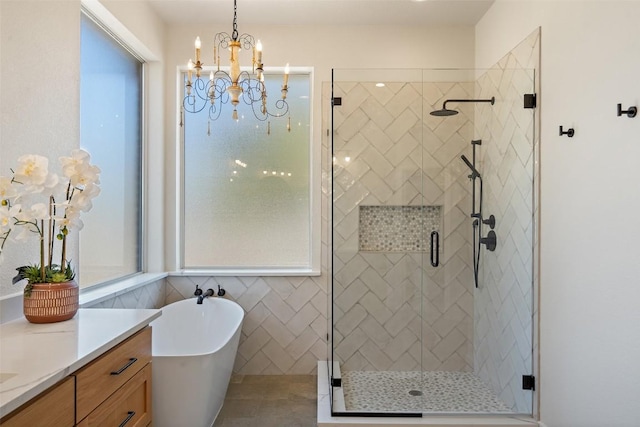 30302 Berry Creek Dr, Georgetown, TX 78628 - bathroom with a shower stall, a soaking tub, vanity, and a chandelier