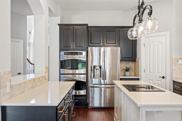 30302 Berry Creek Dr, Georgetown, TX 78628 - kitchen featuring a center island, dark wood-style flooring, decorative backsplash, light countertops, and appliances with stainless steel finishes