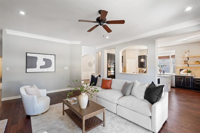 30302 Berry Creek Dr, Georgetown, TX 78628 - living room featuring ceiling fan, arched walkways, ornamental molding, and dark wood-style flooring