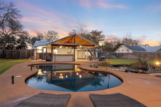 pool at dusk featuring a fenced in pool, a patio area, a fenced backyard, and a gazebo