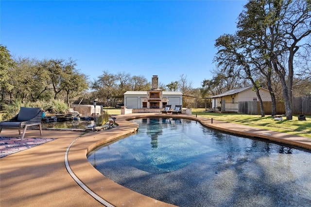 view of swimming pool with an outbuilding, a patio, fence, a yard, and a fenced in pool