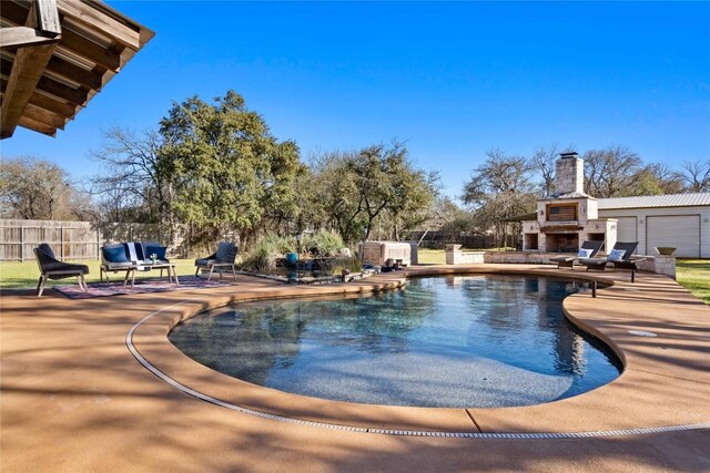 view of pool with a patio area, fence, an outdoor stone fireplace, and a fenced in pool