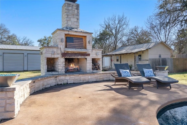 view of patio / terrace with an outdoor stone fireplace and fence