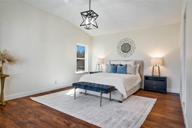 bedroom with lofted ceiling, baseboards, and dark wood-style flooring