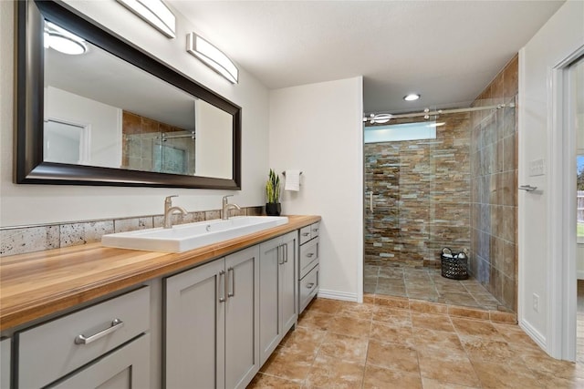 full bath with a stall shower, vanity, and baseboards