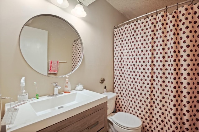 bathroom featuring a textured ceiling, toilet, and vanity