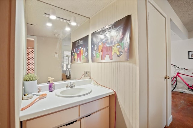 full bath with a textured ceiling and vanity