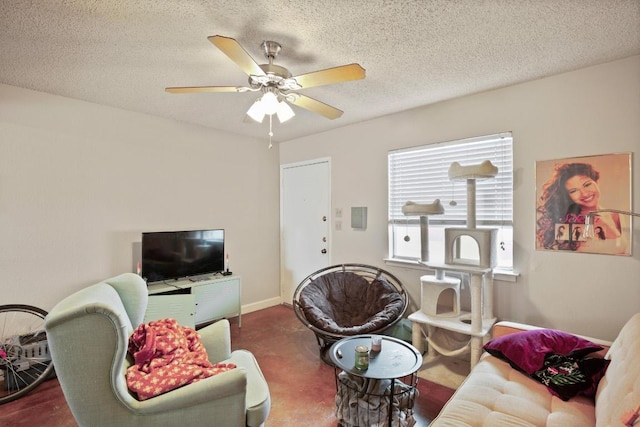 living area featuring a textured ceiling, a ceiling fan, and baseboards