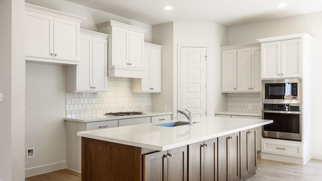 kitchen with a sink, stainless steel appliances, and white cabinetry