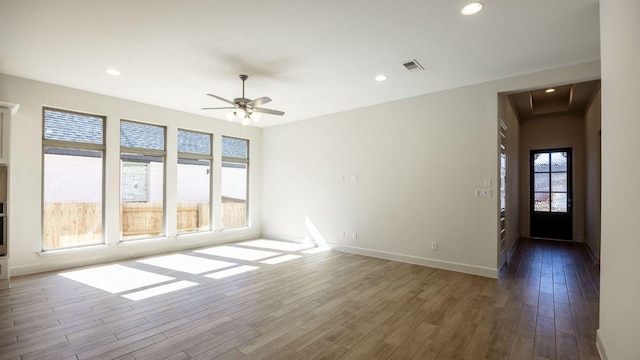 spare room featuring visible vents, baseboards, recessed lighting, wood finished floors, and a ceiling fan