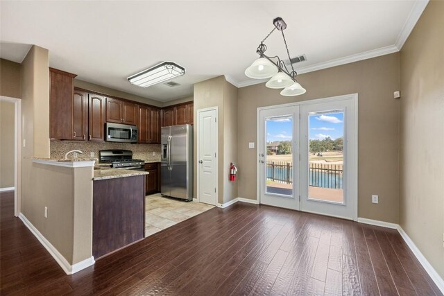 kitchen with visible vents, decorative backsplash, baseboards, appliances with stainless steel finishes, and light wood-type flooring