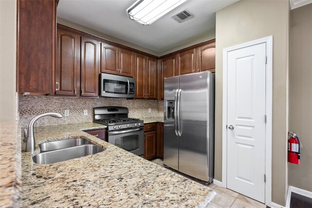 kitchen with stainless steel appliances, visible vents, a sink, and tasteful backsplash