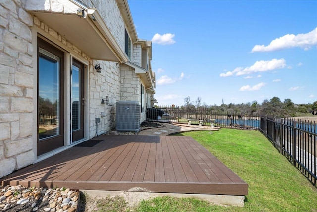 wooden deck with cooling unit, a fenced backyard, and a lawn