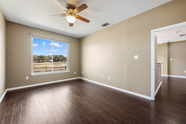 spare room with dark wood-style floors, visible vents, baseboards, and a ceiling fan