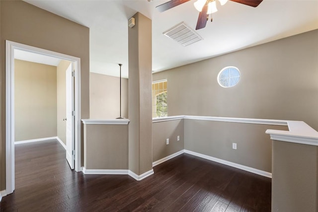 empty room with visible vents, ceiling fan, hardwood / wood-style flooring, and baseboards