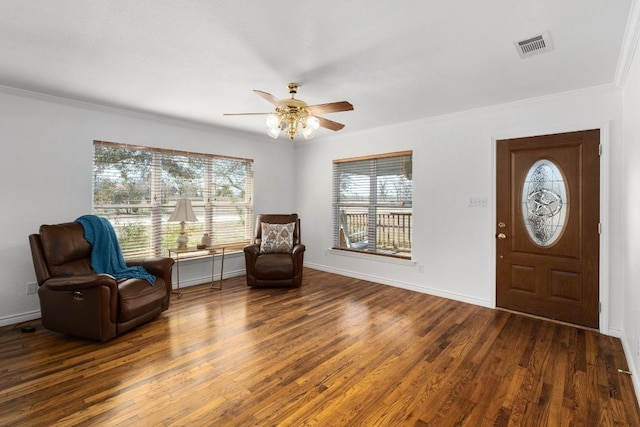 entryway featuring baseboards, visible vents, wood finished floors, and ornamental molding