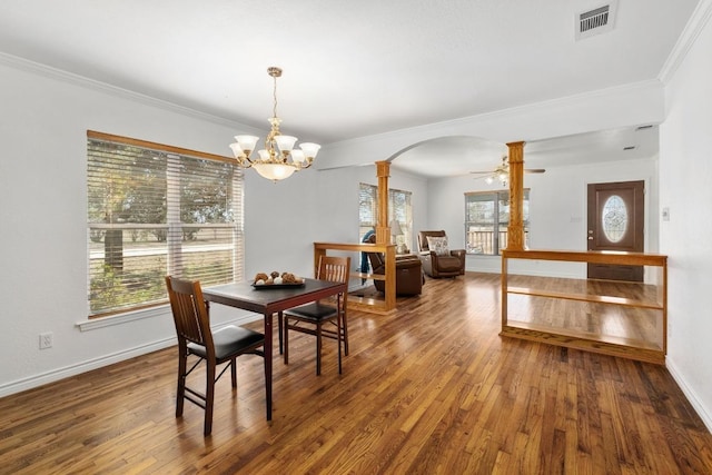 dining area featuring a healthy amount of sunlight, wood-type flooring, visible vents, and arched walkways