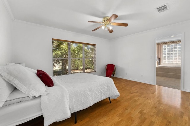 bedroom with multiple windows, visible vents, wood finished floors, and ornamental molding