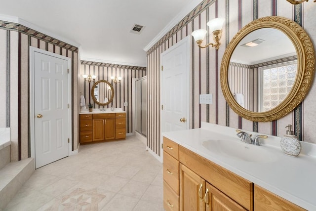 full bath featuring wallpapered walls, visible vents, ornamental molding, a sink, and two vanities