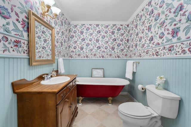 full bathroom featuring toilet, a wainscoted wall, vanity, a freestanding bath, and ornamental molding