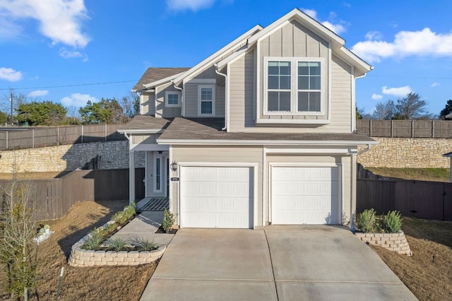 traditional home with driveway, an attached garage, fence, and board and batten siding