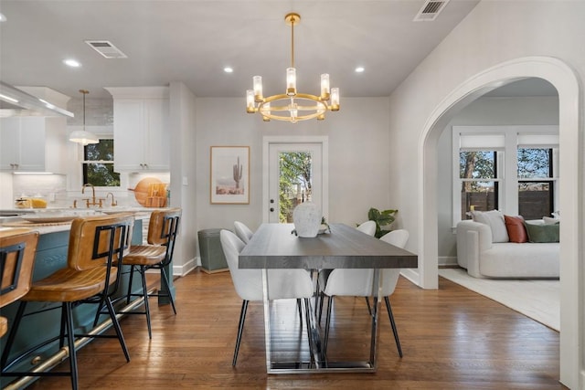 dining room featuring arched walkways, baseboards, visible vents, and an inviting chandelier