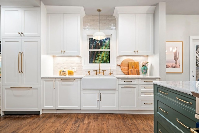 kitchen with dark wood-style flooring, white cabinetry, a sink, and paneled built in refrigerator