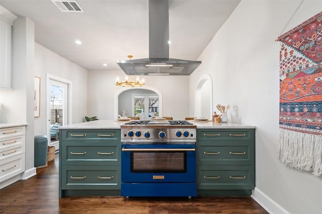 kitchen with plenty of natural light, island range hood, high end stainless steel range, light countertops, and green cabinets