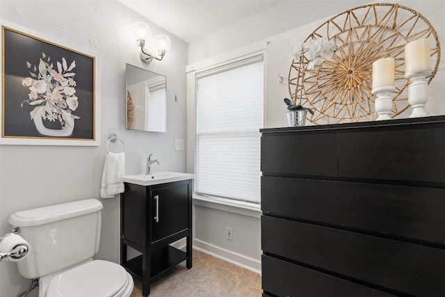 bathroom featuring baseboards, vanity, and toilet