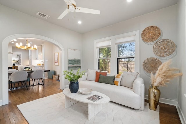 living room with arched walkways, ceiling fan with notable chandelier, recessed lighting, wood finished floors, and visible vents