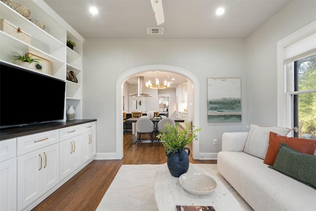 living room with arched walkways, recessed lighting, dark wood-style flooring, visible vents, and baseboards