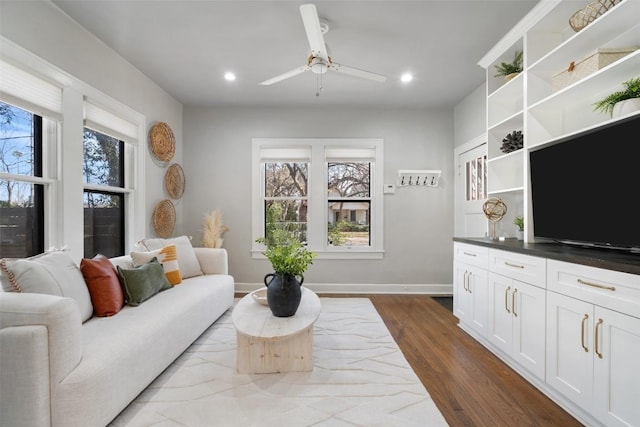 living room featuring a wealth of natural light, dark wood finished floors, baseboards, and recessed lighting