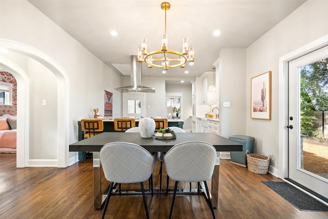 dining room with baseboards, arched walkways, and dark wood-type flooring