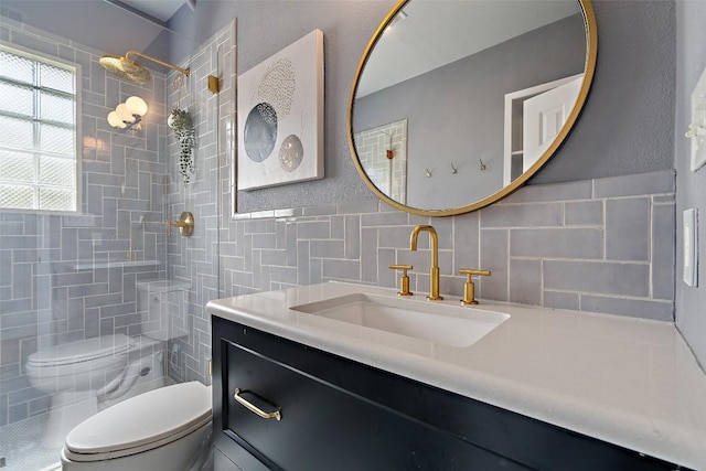 bathroom featuring tiled shower, vanity, toilet, and tile walls