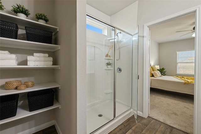 full bathroom featuring a shower stall, wood finished floors, a wealth of natural light, and ensuite bathroom