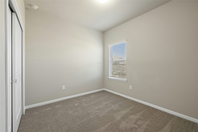 unfurnished bedroom with a closet, carpet, and baseboards