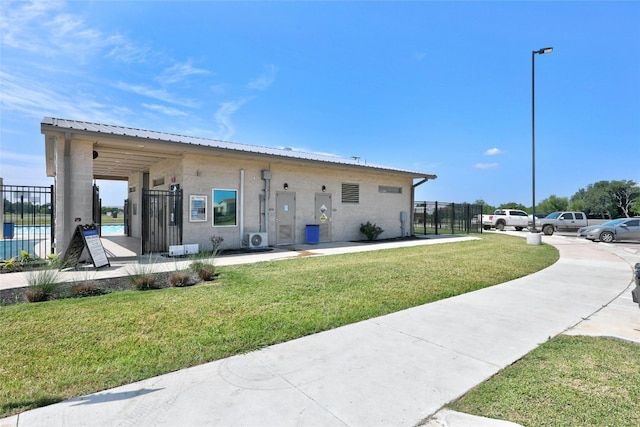 exterior space with metal roof, a yard, and fence