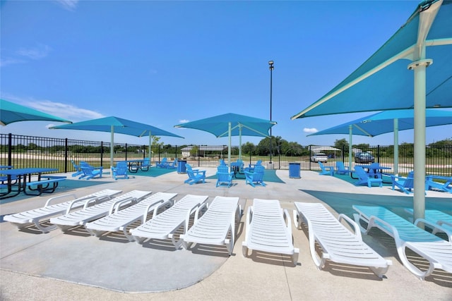 pool with a patio area and fence